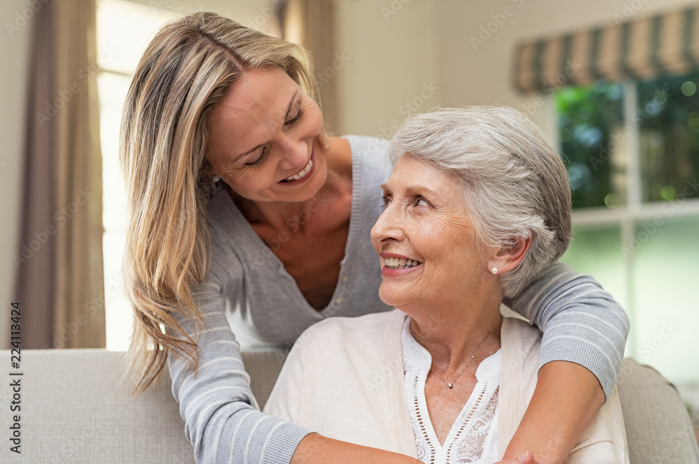 Woman embracing senior mother - obrazy, fototapety, plakaty 