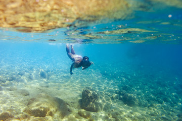 Wall Mural - Young woman snorkeling and diving in tropical sea