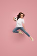 © master1305 - Forward to the victory.The young woman as soccer football player jumping and holding the ball at studio on pink background. Football fan and world championship concept. Human emotions concepts