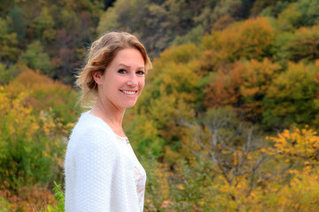 Wall Mural - Beautiful portrait of a gorgeous young woman in the mountains of the Rila national park in Bulgaria with vibrant autumn colors in the forest