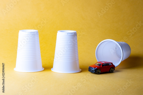Download Three Plastic Disposable Cups On A Yellow Background Under One Of Them Was Hiding A Car Buy This Stock Photo And Explore Similar Images At Adobe Stock Adobe Stock PSD Mockup Templates