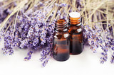 Fototapeta Lawenda - Dropper bottle of lavandula essential oil, bunch of dried purple lavender blossom white table. Herbal aromatherapy & SKincare. 