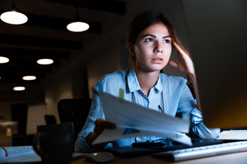 Wall Mural - Woman graphic designer using pc computer working with documents at night in office.