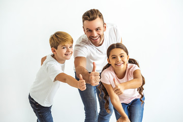 Wall Mural - The father and kids thumbs up on the white background