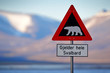 Red road traffic sign with Polar bear. “Gjelder Hele Svalbard” means “Over All of Svalbard (watch out for polar bears)”. Polar bear with snowy mountain, Svalbard. Travelling in the Arctic.