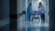 © Gorodenkoff - Emergency Department: Doctors, Nurses and Paramedics Push Gurney / Stretcher with Seriously Injured Patient towards the Operating Room. Bright Modern Hospital with Professional Staff Saving Lives.