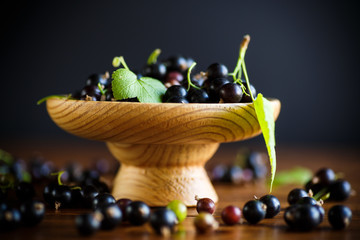 Canvas Print - ripe berries black currants on a wooden table