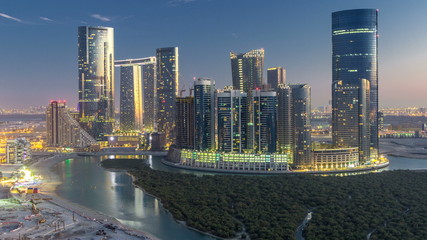 Buildings on Al Reem island in Abu Dhabi day to night timelapse from above.