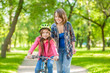 mother teaches her daughter to ride a bicycle