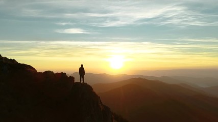 Wall Mural - the male standing on the mountain and enjoying the beautiful sunset