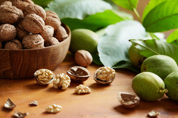 Wall Mural - Fresh walnuts with and without shells on a wooden surface