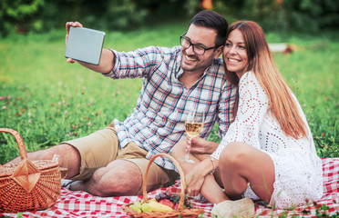 Wall Mural - Couple enjoying picnic together. Love and tenderness, dating, romance, lifestyle concept