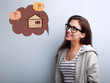 Happy thinking casual woman in eyeglasses looking up on illustration house in bubble cloud above with questions sign. Insurance protection concept, investment to safety money.