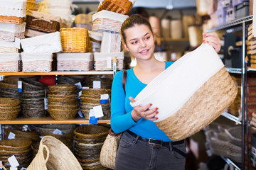 Pretty female  buyer choosing wicker bag