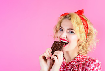 I like tasty sweet food. Sexy woman eating chocolate brick. Happy beautiful lady bites chocolate tile. Pin up girl. Girl tasting sweet chocolate. Woman with bright makeup eat chocolate bar. Copy space