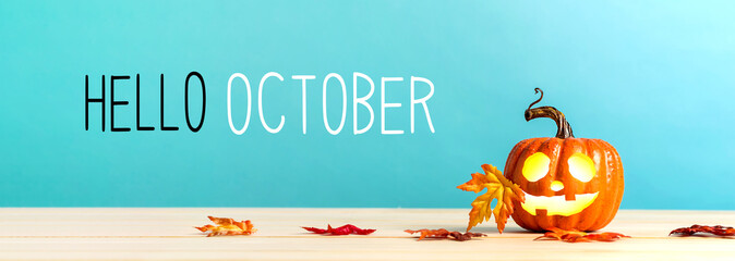 Wall Mural - hello october messag with pumpkin with leaves on a blue background