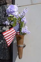 Patriotic Grave Memorial With All Weather Blue Violet Artificial Flowers And American Flag On Mausoleum Wall