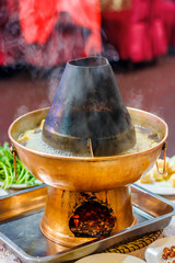 Asian traditional double hot pot close-up with lettuce leaves