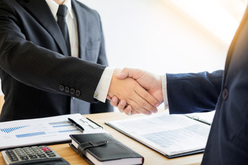 Wall Mural - two business men partners shaking hands during a meeting to deal complete to sign agreement contract and become success in the office.