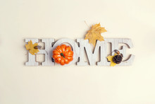 Decorative Word Home With Pumpkin And Fallen Leaves On On Beige Background. Copy Space For Text.