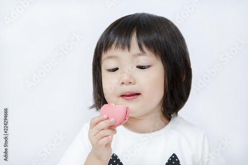 スイーツのマカロンを手に持ち食べている幸せ表情の幼い女の子 幸せ スイーツ 食欲 楽しい 子供 幼児イメージ Buy This Stock Photo And Explore Similar Images At Adobe Stock Adobe Stock