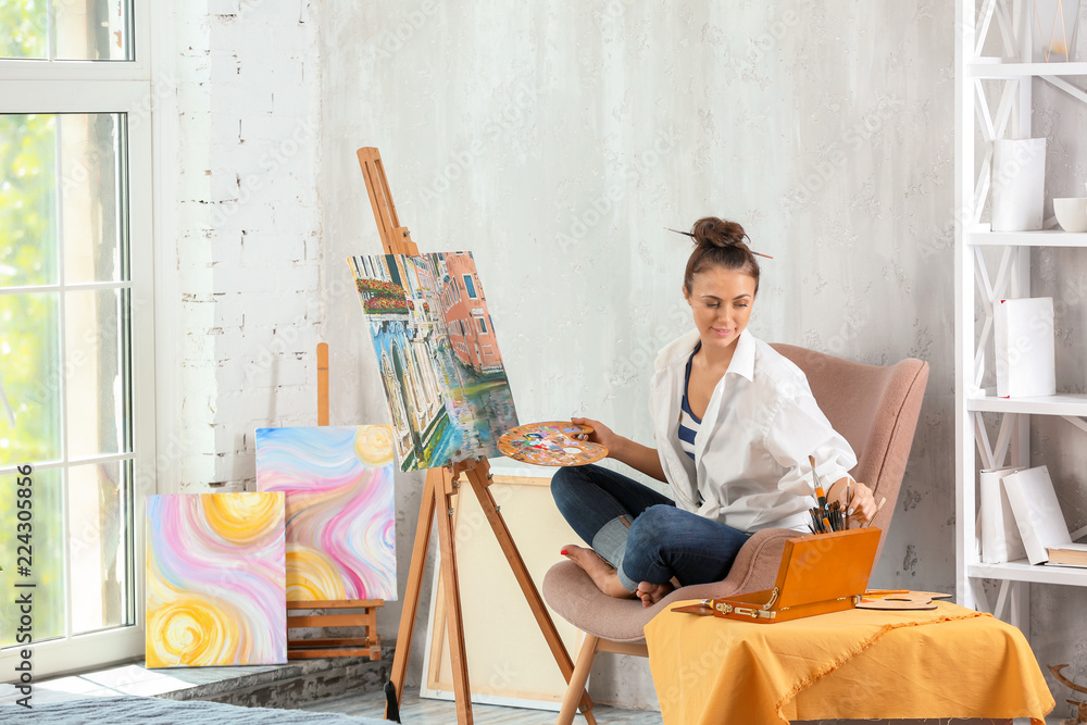 Female artist painting picture in workshop