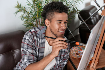 Wall Mural - Young African-American artist painting picture in workshop