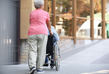 Poster - Senior man in wheelchair and his wife on ramp outdoors