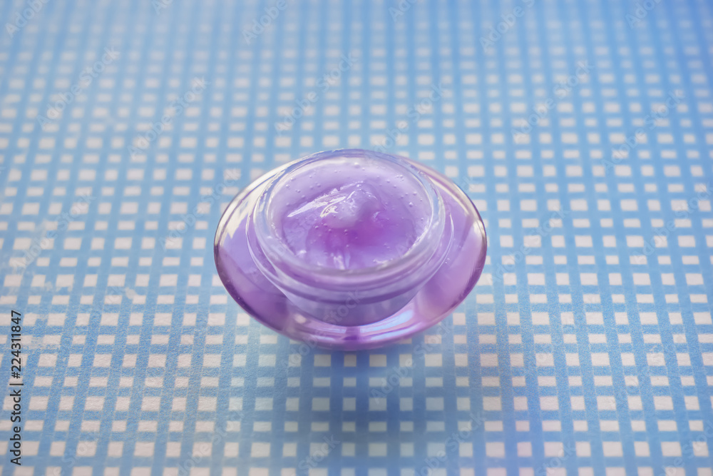 Jar with body cream on color table