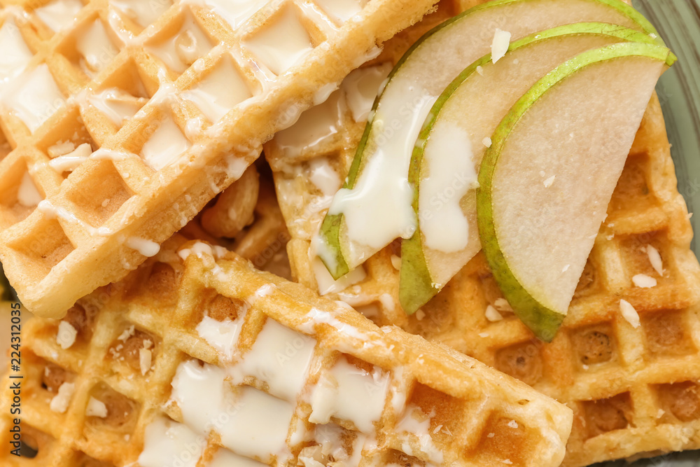 Delicious waffles with pear slices and sauce, closeup