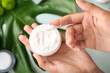 © Pixel-Shot - Woman holding jar of natural cream, closeup