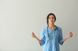 © Pixel-Shot - Female nurse meditating on light background