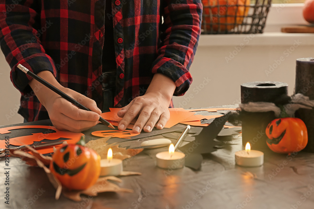 Woman making decorations for Halloween party at table