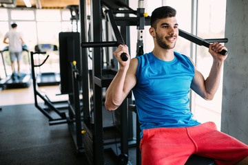 Fit man exercising at the gym on a machine