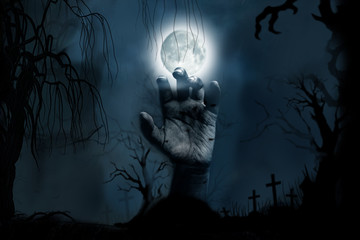 Wall Mural - Hand rising from the ground in the cemetery on Halloween Concept.