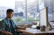 © mavoimages - Young Asian designer using a tablet at his desk