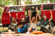 © Drobot Dean - Group of friends hippies men and women rejoicing, and sitting near vintage minivan into the nature