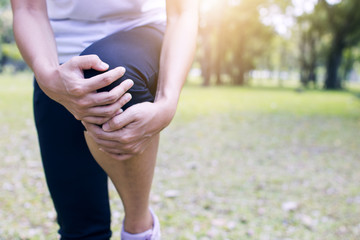 sport woman has knee pain or leg injury after work out in park