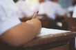 © arrowsmith2 - School students taking exam writing answer in classroom with stress