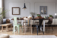 Lamp Above Wooden Table With Flowers In Modern Grey Dining Room Interior With Chairs. Real Photo