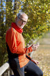 © 2Design - Senior runner man watching his smartphone after jogging