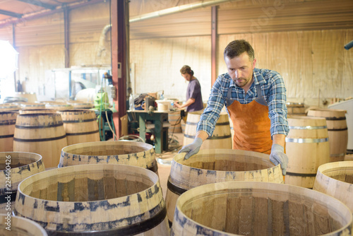 Fotografie, Obraz wood barrels production cooper using hammer and tools in workshop