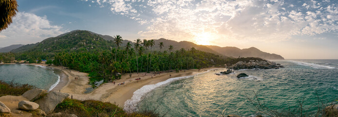 Beautiful Caribbean beach with palm trees and sunset in Tayrona National Park close to Santa Marta in Northern Colombia