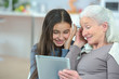 Grandmother looking at tablet with granddaughter