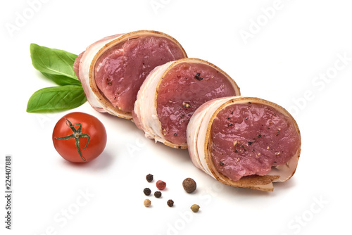 Fotomural Raw Pork medallions wrapped in bacon with basil leaves and peppercorns, isolated on white background