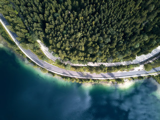 Canvas Print - Aerial view of the road near the lake and the forest from above