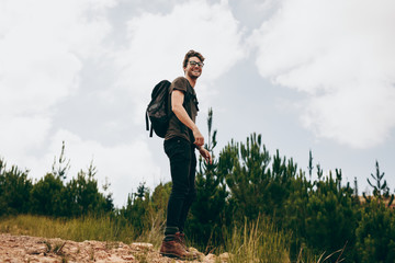 man hiking in forest looking back