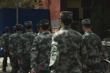 Chinese soldiers with there uniforms walking on a street of Beijing