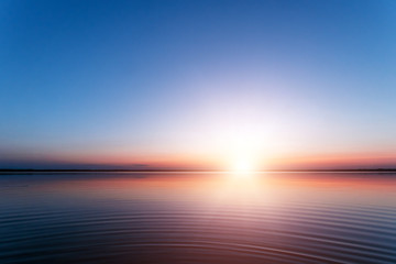 beautiful, red dawn on the lake. the rays of the sun through the fog. the blue sky over the lake, th