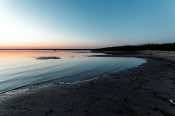 Wall Mural - Beautiful, red dawn on the lake. The rays of the sun through the fog. The blue sky over the lake, the morning comes, the sky is reflected in the water.